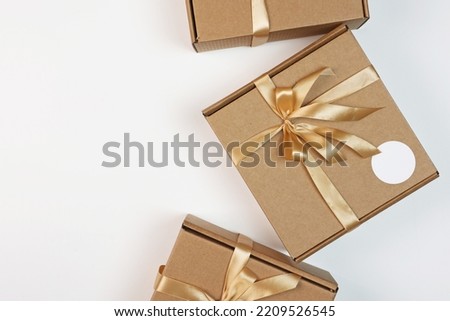 Cardboard boxes with satin ribbon. Packaging for a gift. Photo on a light background. Flat lay.Top view.Copy space.Eco-friendly packaging.An empty label for the label.