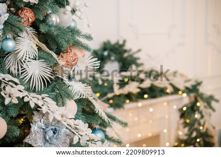 The Christmas tree is decorated for Christmas. Beautifully decorated house with silver, white and Christmas tree and presents. A magical time. New Year