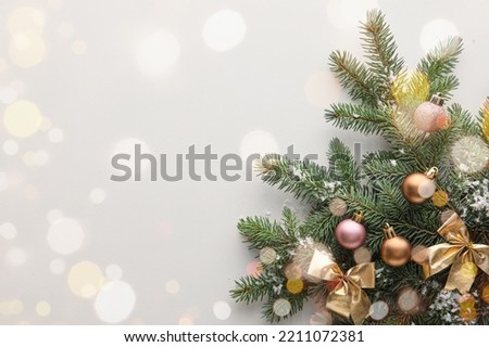 Beautiful Christmas tree branches with decor on light background with space for text