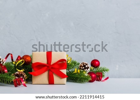 New Year Christmas mood, gift box, branches of a christmas tree, New Year decorations on a colored background.