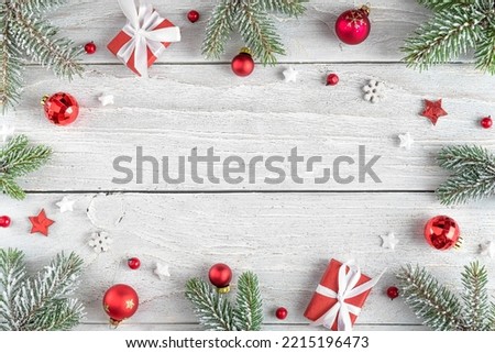 Christmas composition. Frame made of fir tree, festive red decorations, gift boxes on white wooden background. Flat lay. Top view with copy space. Winter holidays concept