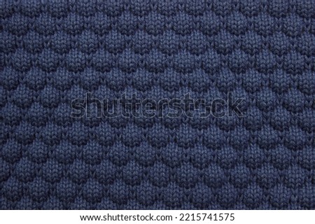  Blue background of knitted fabric, sweater close-up, concept of warm autumn and winter clothing, care washing and dry cleaning, with an empty space for the fabric, copy space, decoration, packaging
