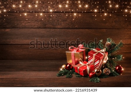 Merry Christmas and Happy New Year. Boxes with gifts, Christmas toys and fir branches on a wooden background