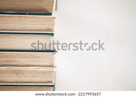 Old books stacked on a white background.