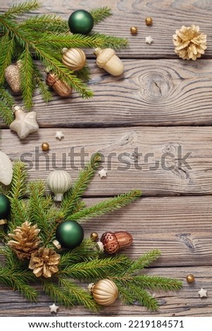 golden christmas toys with fir branches on dark wooden background