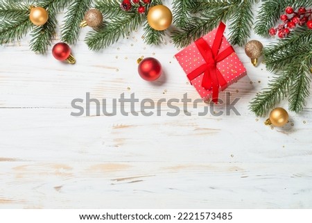 Christmas present box with red ribbon and holiday decorations.