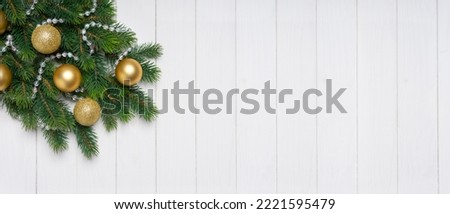 Christmas tree branch decorated with golden balls on white wooden background. Top view, flat lay with copy space, banner, header, New Year background