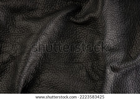 black leather texture, close-up of black genuine leather. Leather top view in folds and bumps.