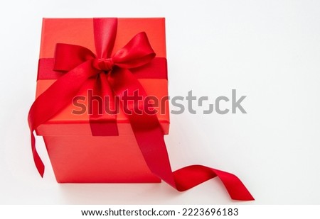 Red gift box with red passion ribbon isolated cutout on white background. Valentine Day Anniversary Xmas Birthday present. Copy space
