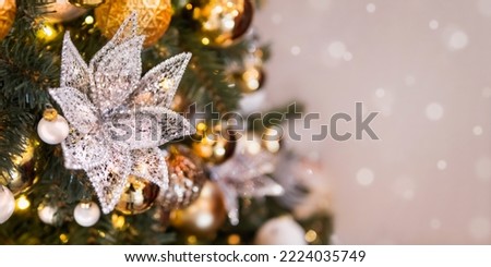Christmas tree with shiny decorations. Fir tree decorated with light bulbs, lace flower and golden balls for New Year celebration.