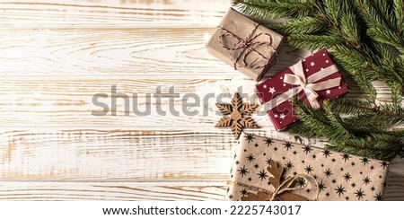Christmas background with fir branches, pinecones, gift box on the old white wooden board. Top view. copy space