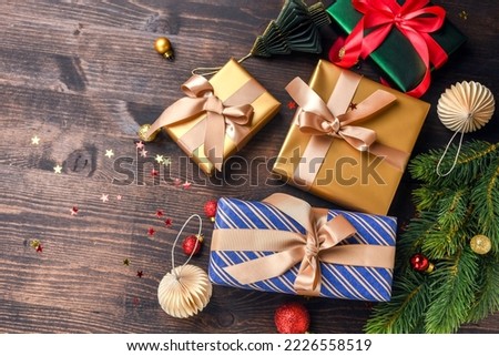 Festive christmas new year background colorful gift boxes and holiday decorations on wood background. New Year's present and Christmas present top view