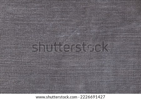 A denium gray jean closeup, background with space for text. View of old jeans details. Denim background, texture