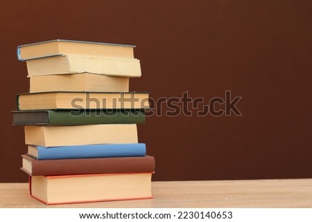 A pile of books on a brown background