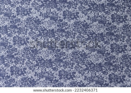 Blue and white fabric with flowers ornament close up. Background of textile with plant picture.
