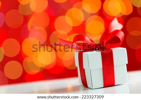 Gift box with red ribbon on Christmas theme background