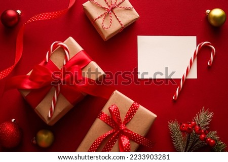 Christmas ornaments, gifts and decoration with white empty blank greeting or business card or thank you note on festive red background as happy holidays flatlay.