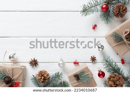 Christmas background with eco-packed gifts, blue fir branches on a white wooden background. Space for copying. Flat position, top view.