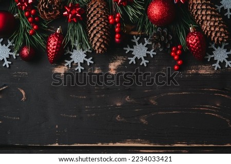 Christmass background red christmas tree toys, silver snowflakes and spruce brance on wooden background.
