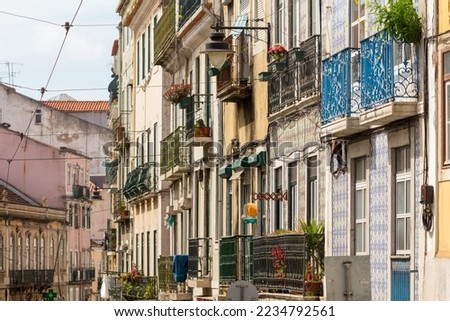 Street view of colorful traditional houses in Lisbon historic center, Portuguese tiles in a facade, Portugal