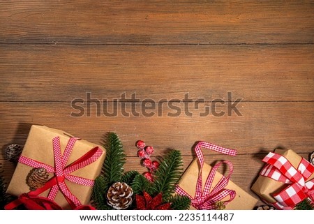 Traditional Christmas, New Year holidays background with Christmas tree branches, winter red berries, poinsettia flowers, gift boxes, on wooden background  top view copy space