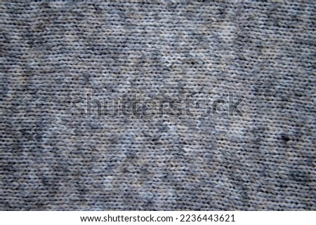 Soft and warm knitted fabric in gray. Fine wool uniform knit. Texture for background or illustration