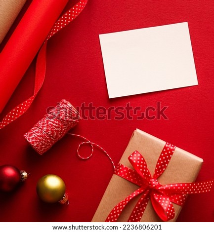 Christmas ornaments, gifts and decoration with white empty blank greeting or business card or thank you note on festive red background as happy holidays flatlay.