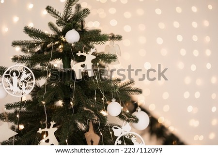New Year, Christmas background. New Year's decor on a white table, decorative firs, gift and white house. Front view