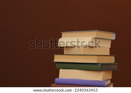 A pile of books on a brown background