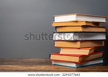 Composition with vintage old hardback books, on wooden table and gray background. stack of books. Back to school. Education.
