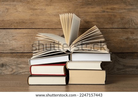 Stack of hardcover books on wooden table