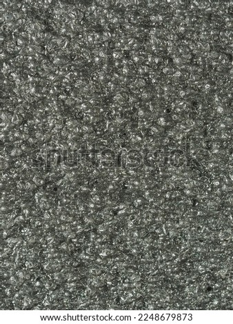 close up, background, texture, large vertical banner. surface structure black expanded polyethylene, EPE, padding cushioning material for packages. full depth of field. high resolution photo