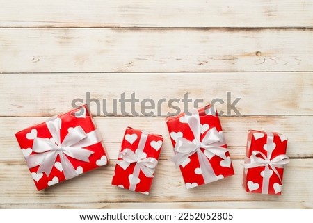 Gift boxes with hearts on wooden background, top view
