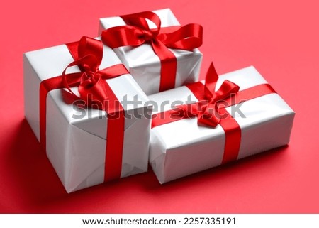 Gift boxes with beautiful bows on red background. Valentine's Day celebration