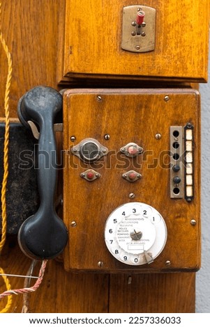 Old telephone device on a wooden panel