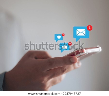Social media marketing concept on mobile phone, notification icons such as message, comment and heart on smartphone screen.