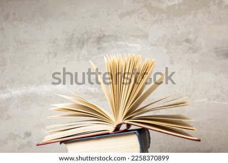 Vintage old hardback books, diary, fanned pages on wooden desk table and grunge background Daylight. Books stacking. Back to school. Copy Space. Education background