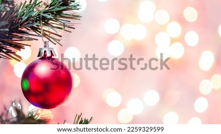 Christmas decoration. Red balls hanging on pine branches Christmas tree garland and ornaments over abstract bokeh background with copy space