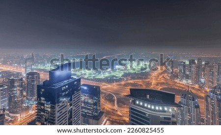 Panorama of Dubai Marina with JLT skyscrapers and golf course night , Dubai, United Arab Emirates. Aerial view from above towers. City lights illumination