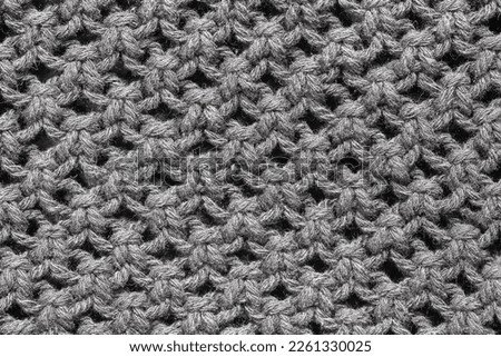 Knitwear background. Black woolen fabric texture. Warm jumper closeup. Yarn textile backdrop. Handmade sweater texture. Dark cotton pattern.