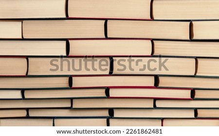 books piled up in the shape of a wall as if they were bricks