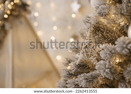 New Year's decor on the Christmas tree, wooden star, bokeh, lights