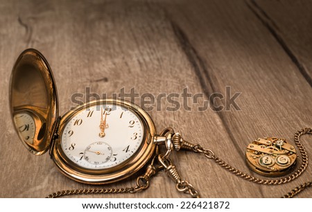 Vintage watch on a wooden background showing five to twelve, text space