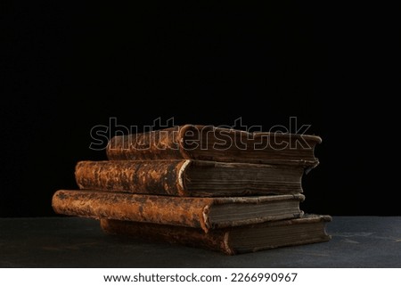 Old books. Four volumes of old books on a black background. The concept of knowledge and collecting. The old library. Copy space.