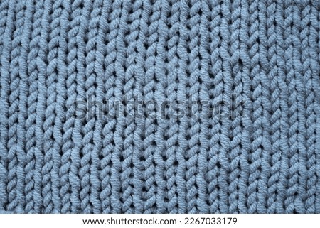 Knitted grey background, gray sweater cozy pattern.