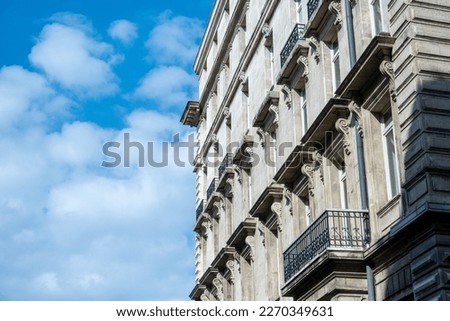 It depicts a modern building with a blue sky and clouds in the background. It can be used in designs associated with architectural design, city life, modernity and high technology.