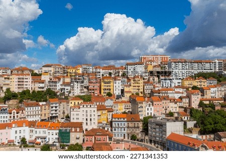 Cityscape of colorful traditional houses in Coimbra historic center with blue sky and heavy clouds, Portugal