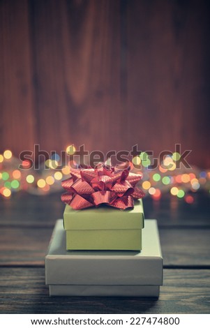 Stack of gift boxes with red bow over wooden background