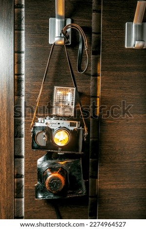 vintage film camera in a case hanging in the hallway on a belt lamp lighting interior design collectibles