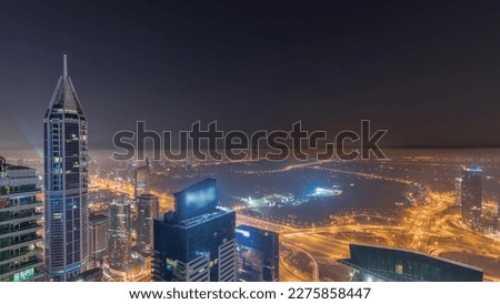 Aerial skyline with Golf Club, hotels and residential areas far away in desert in Dubai during all night  with fog, UAE, top view from Dubai marina skyscrapers. Lights turning off